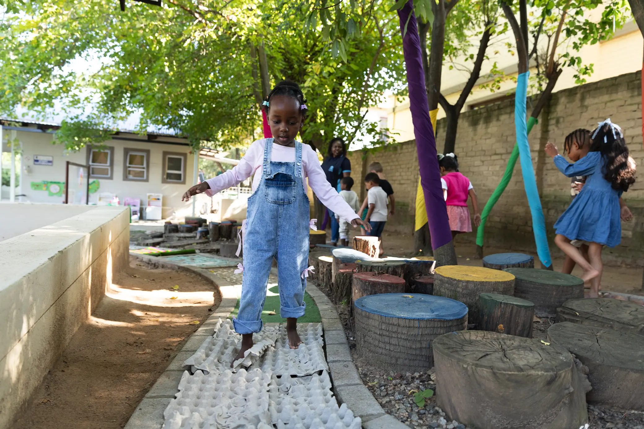 Nursery children playing outdoors under trees at Summerhill