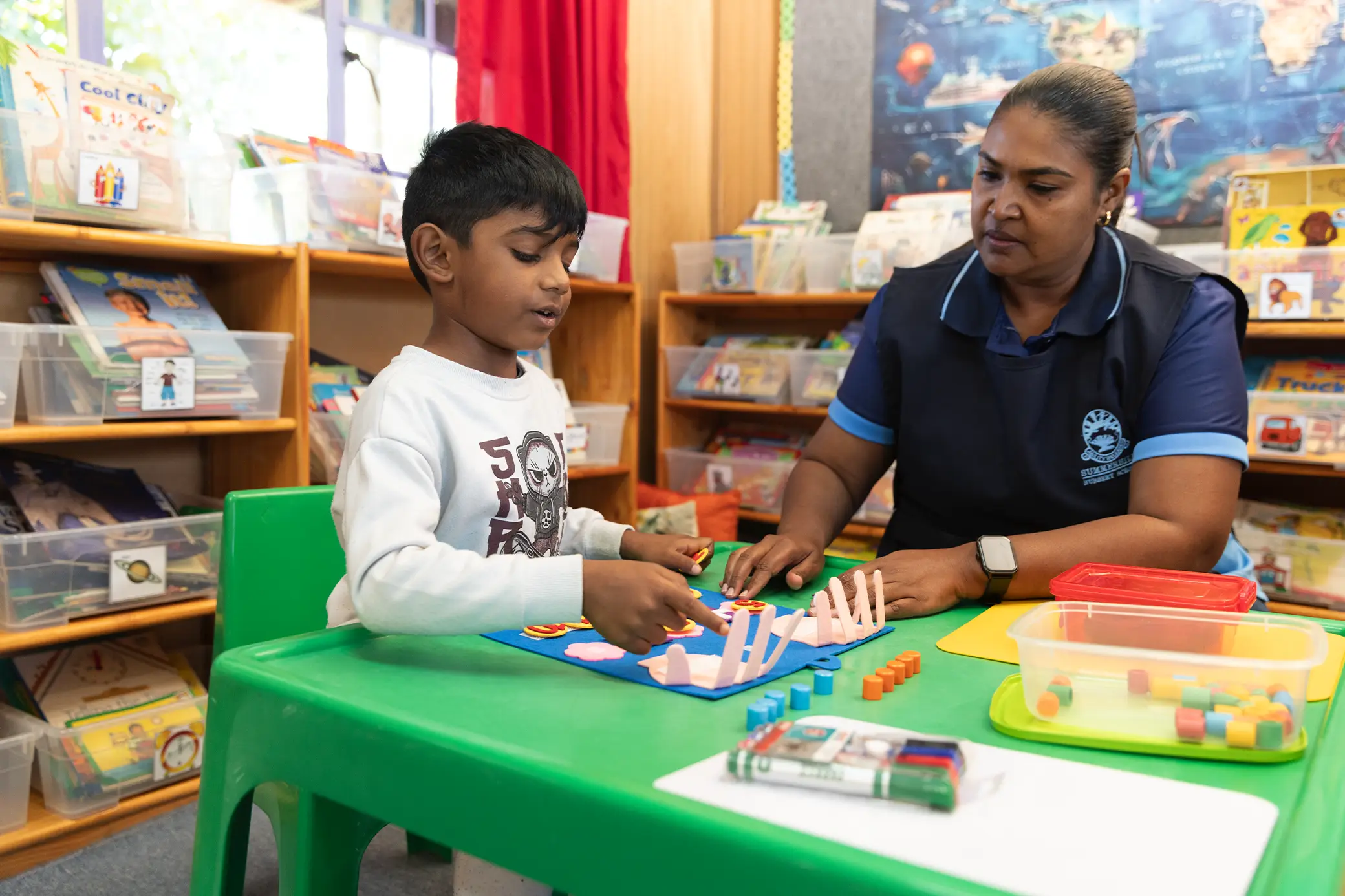 Hands-on learning with a teacher at Summerhill Nursery